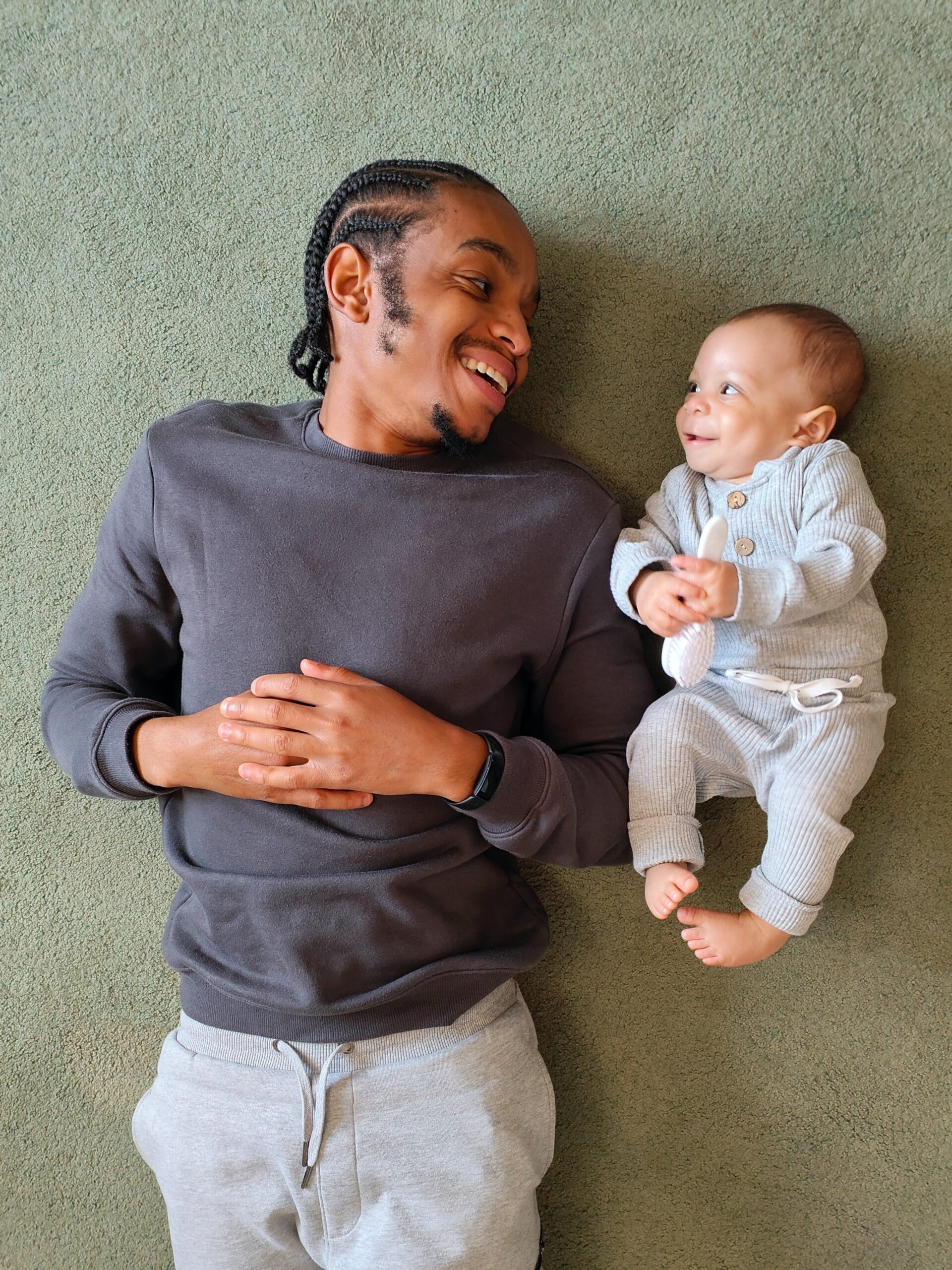 Father and child lie on the floor together