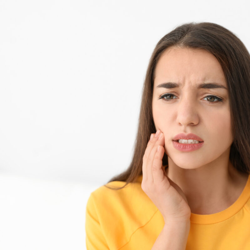 young woman with tooth pain needs a cavity filling
