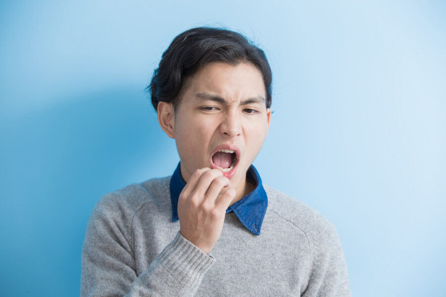 young man with a toothache on blue background
