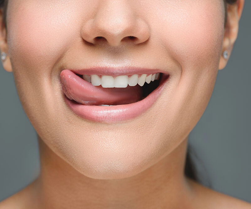 close up of woman sticking tongue out sideways