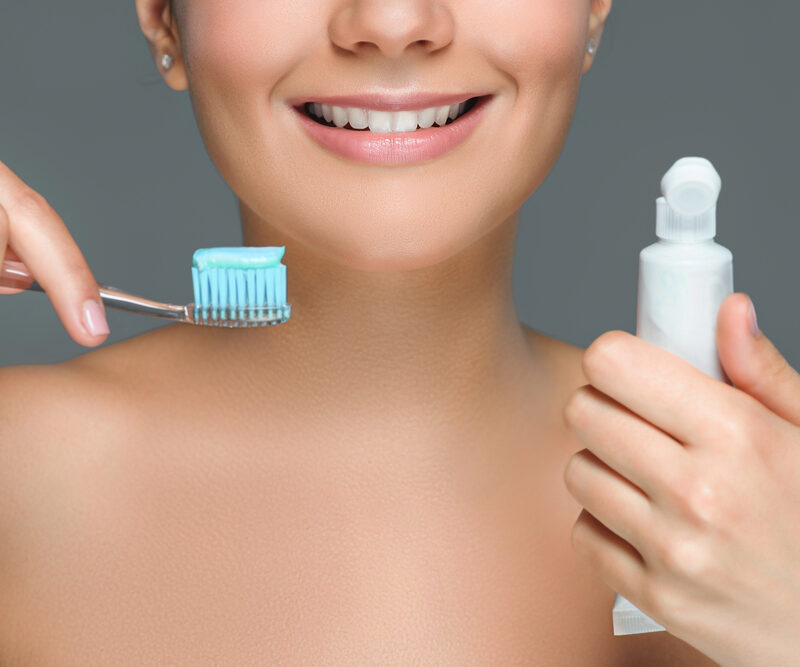 woman holding a toothbrush and toothpaste