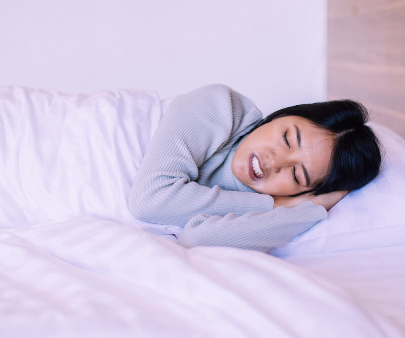 Beautiful asian woman sleeping on bed and grinding teeth,Female tiredness and stress