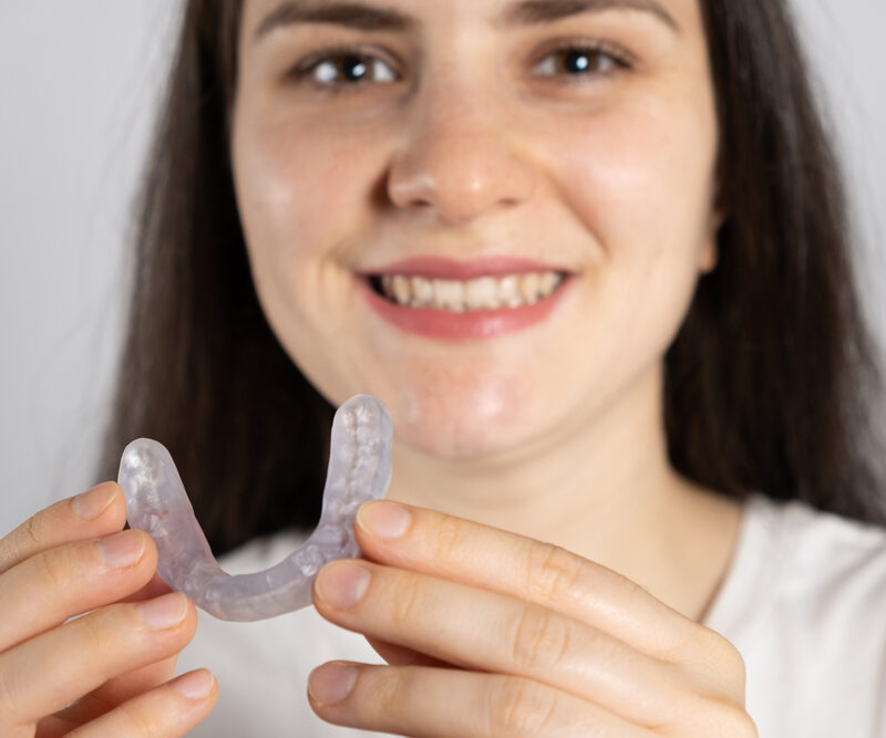 woman holding her mouthguard