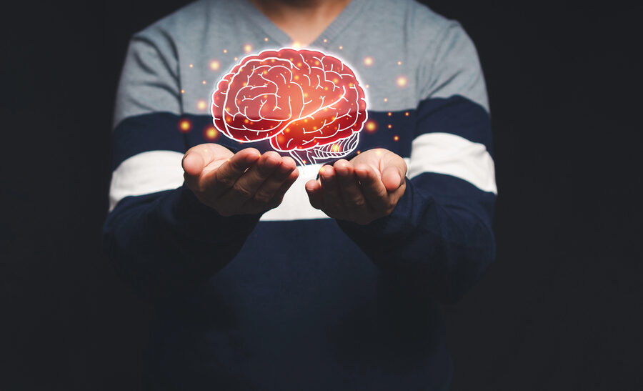 man holding depiction of brain in the palm of his hands