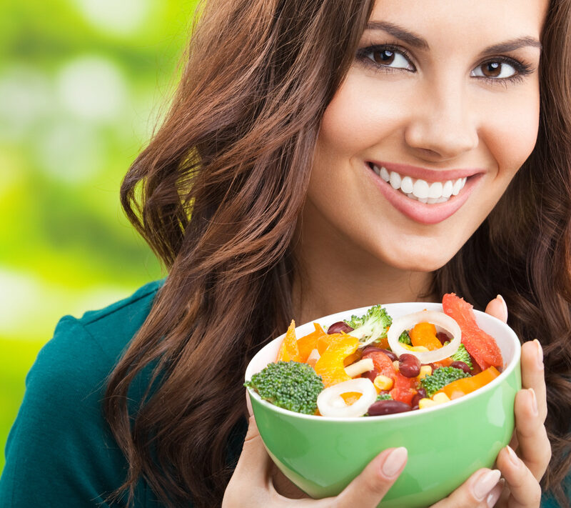 brunette woman holding a bowl of salad