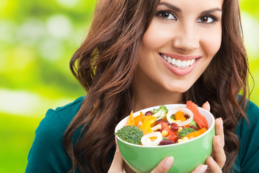 brunette woman holding a bowl of salad